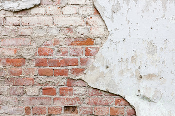 Aged brick wall with cracked plaster