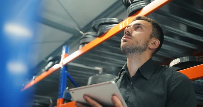 wholesale, delivery, logistic, business, export and people concept - happy man or manager with tablet pc computer at warehouse