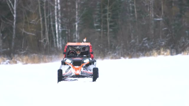 Winter racing side-by-side vehicles. Rally on the buggy on the snow on a winter day. Racing in the SXS class. Buggy, sports car on rally. Off Road Series racing. Slow motion.