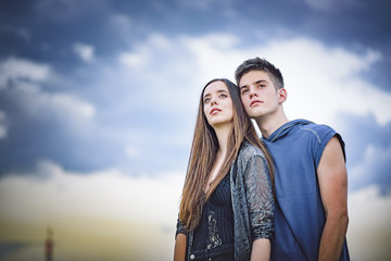 Romantic young teenage couple in love hugging, enjoying a sunny day outside