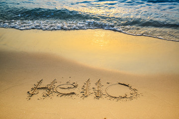 Hello message written in tropical beach sand