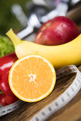 Fitness concept with dumbbells and fresh fruits