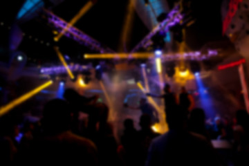 Obraz na płótnie Canvas Blurry night club dj party people enjoy of music dancing sound with colorful light. club night light dj party Ibiza club. With Smoke Machine and lights. Dark background.