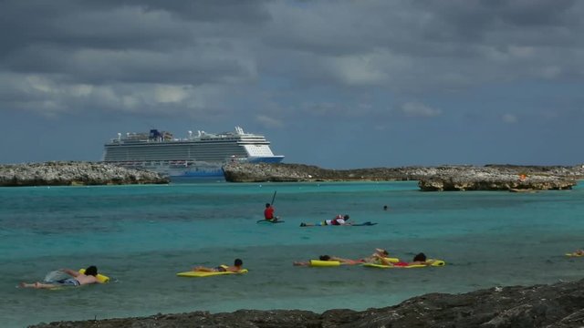 Tourists are floating on the air matresses near the shore,cruise ship in the background,Bahamas 13th of December 2016.