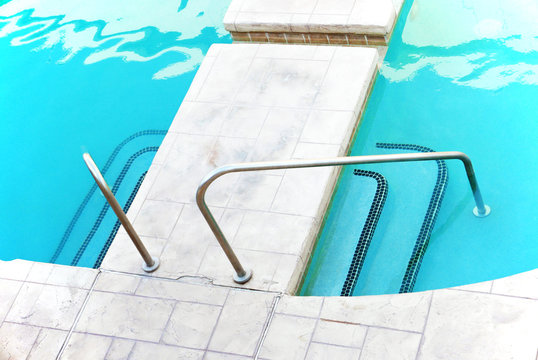 Staircase into swimming pool with railing on both sides, seen from above