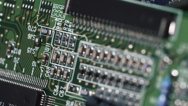 Macro shot of technology background. Electronic circuit chips on PC board rotating. Shallow depth of field.