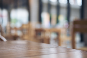 Wooden table and chair in cafe with blur bokeh abstract vintage background