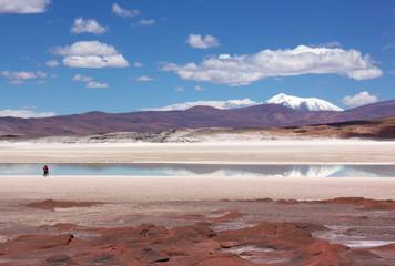 Travelers looking at Atacama Desert majestic landscape, San Pedro, Chile. Desert colors of red...