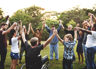 Group of people holding hand together in the park