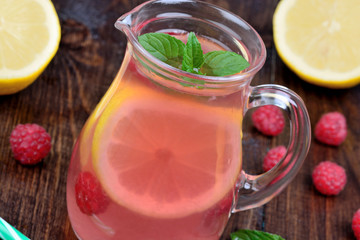 Raspberry lemonade with mint in a pitcher on table