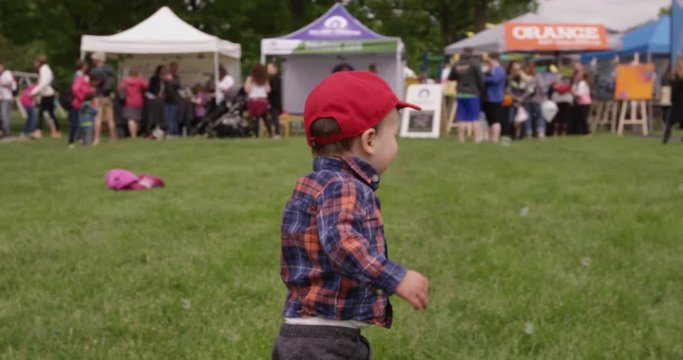 Toddler boy running around at outdoor festival