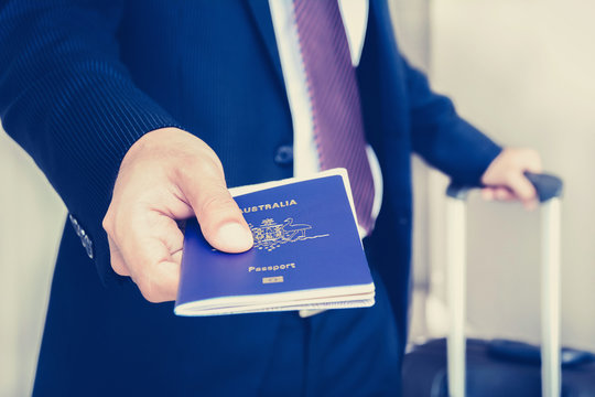 Businessman giving passport with boarding  pass inside