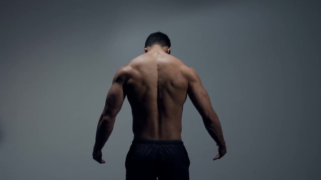 Fitness model flexing back muscles. 