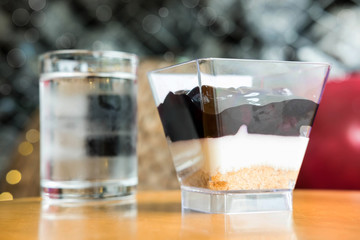 Blueberry cheese cake and cool water on wooden desk