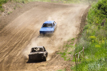 Fototapeta na wymiar Old wrecked cars stock race. Racing in the open air with dust