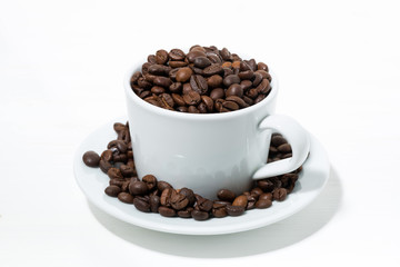 cup with coffee beans on white background, closeup