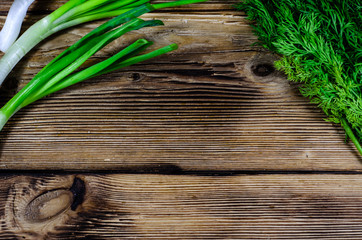 Green dill and onion on wooden table. Top view