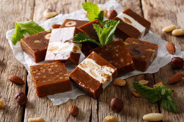 Square sweets toffee with nuts decorated with mint closeup. horizontal