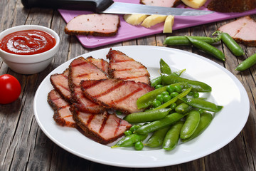 grilled slices of meat,  green pea pods