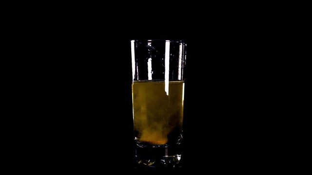 yellow effervescent tablet falling in  glass of water