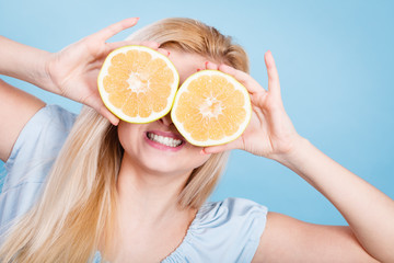 Girl covering her eyes with grapefruits