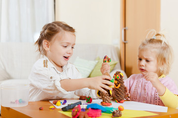 Fototapeta premium girls playing with plasticine at house