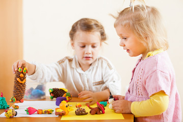 Preschoolers molding figurines from plasticine