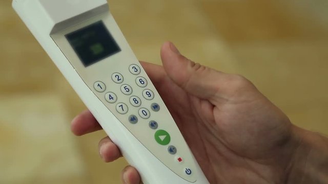 Tourist choosing settings on control panel of audio guide by pressing buttons