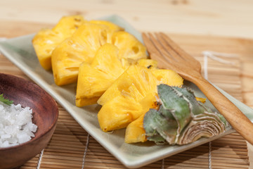 fresh slice of sweet pineapple on bamboo mat and salt
