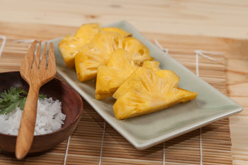 fresh slice of sweet pineapple on bamboo mat and salt