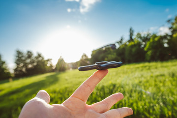 Fidget spinner in hand, summer background