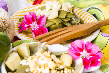 Bowl of green beans with egg on tablecloth with flowers