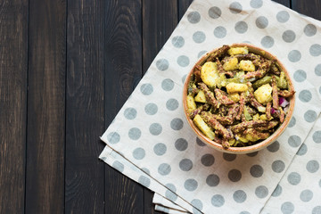 Bavarian salad with smoked meat on a dark background