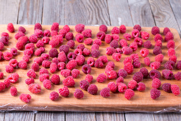 Frozen raspberries on a wooden background