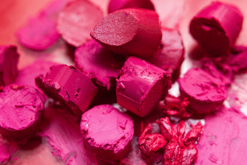 Many pink lipsticks cut into pieces top view. Chopped cosmetics, beautiful style, creative...