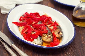 grilled sardines with red pepper on white dish