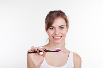 girl holding a toothbrush smiles