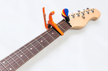 Electric guitar neck with a capo and picks