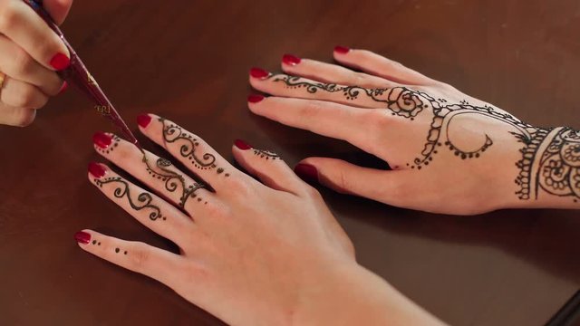 Two female's hands with the image of mehendi henna patterns.