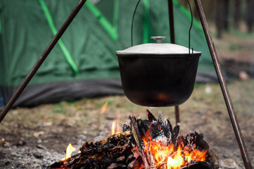 Hiking pot in the bonfire. Traveling in the mountains with tents