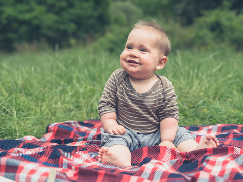 Cute little baby in nature on picnic laughing