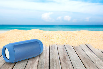 Portable wireless speakers on the beach and blue sky.