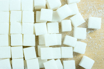 close up of white sugar cubes on wooden table.