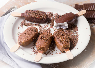 Chocolate ice cream popsicles on white plate