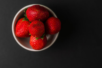 fresh Strawberry in white  bowl on black background.