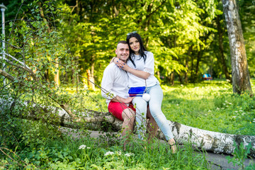 portrait of young couple on background summer green park.