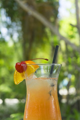 Tropical cocktail with orange and cherry garnish