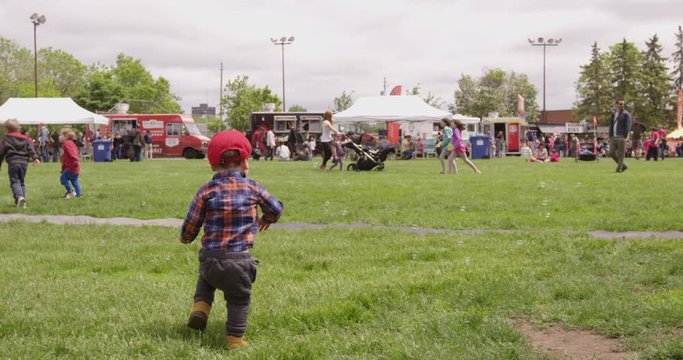 Toddler boy chases bubbles at outdoor festival