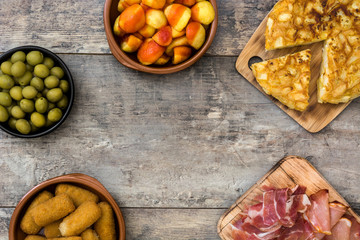 Traditional spanish tapas. Croquettes, olives, omelette, ham and patatas bravas on wooden table

