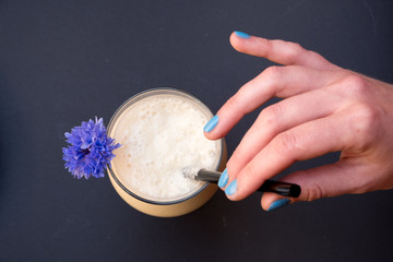 Cup of coffee in hands. Top view. Blue flower